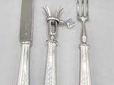 three forks and a knife on a white table