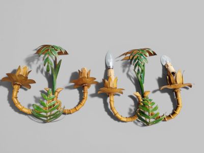 two wall sconces with palm trees and birds on them