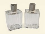 two bottles of perfume sitting next to each other on a white surface