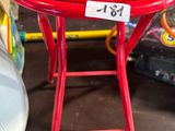 une petite table rouge sur laquelle est posée une étiquette de prix