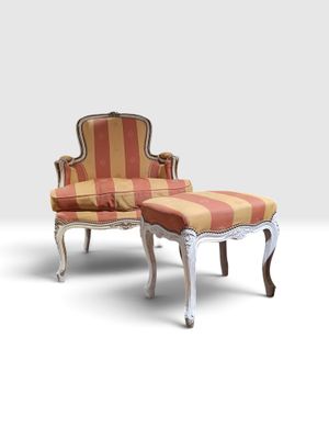 une photo d'une chaise et d'un pouf dans une pièce blanche