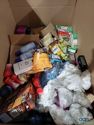 a cardboard box full of food and other items