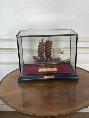a miniature model of a chinese ship in a glass case