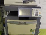 a printer sitting on top of a desk next to a pile of papers