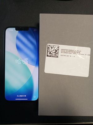 une boîte sur laquelle est collé un autocollant, posée à côté d'un téléphone