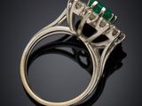 a close up of a ring with a green stone in it