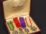 five medals in a case on a black surface