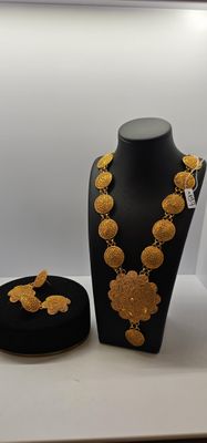 un collier et des boucles d'oreilles exposés dans une vitrine d'une bijouterie