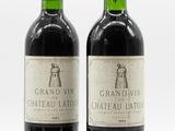two bottles of wine sitting next to each other on a white surface