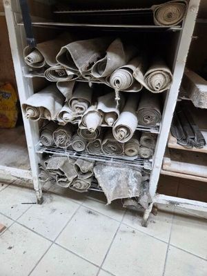 de nombreux rouleaux de tissu posés sur une étagère dans une pièce