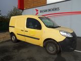 La petite camionnette jaune est garée devant un immeuble.