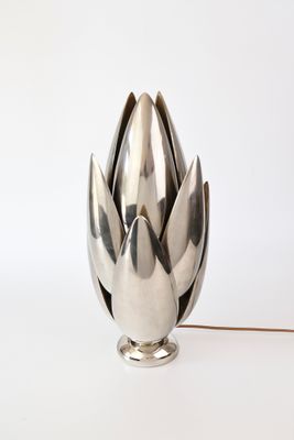 un vase en argent posé sur une table blanche
