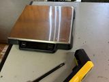 a laptop computer sitting on top of a table next to a hammer