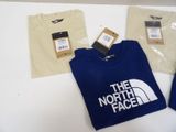 the north face t - shirts are on display on a table