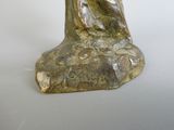 a statue of a woman sitting on top of a rock