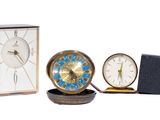 trois horloges différentes posées les unes à côté des autres sur une table