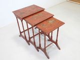 two red nesting tables sitting on top of each other on a white floor