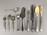 beaucoup d'argenterie sur une table avec des cuillères et des couteaux