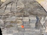 un gros morceau de bois posé par terre à côté d'un tas de pierres