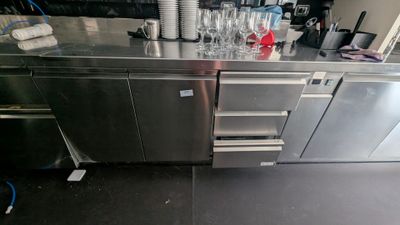 un plan de travail en inox sur lequel sont posés plusieurs verres à vin