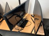 three monitors sitting on a desk with wires on them