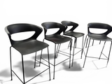 three black chairs sitting next to each other on top of a white floor