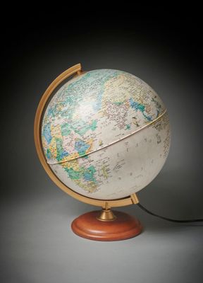 un vieux globe terrestre posé sur un socle en bois, sur fond noir