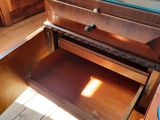 a wooden dresser with a glass top in a room