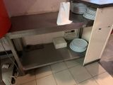 une cuisine avec un évier et un plan de travail sur lequel sont posées des assiettes