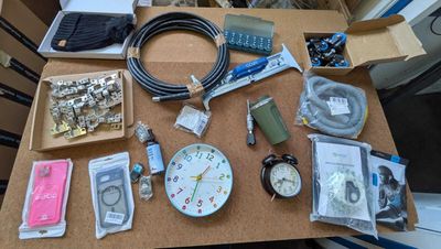 une table sur laquelle se trouvent de nombreux objets, notamment une horloge et d'autres objets