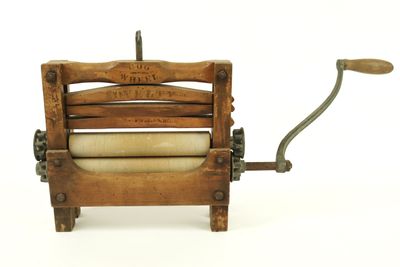 an old wooden machine with a roll of toilet paper in it