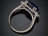 an oval sapphire and diamond ring on a black surface