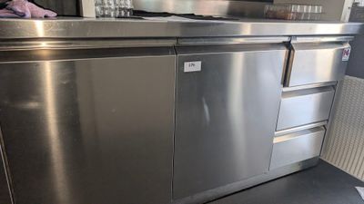 une cuisine en inox équipée d'un lave-vaisselle et d'un micro-ondes