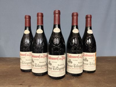 four bottles of wine are lined up on a wooden table
