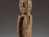 une statue en bois d'un homme avec un chapeau sur la tête