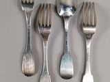 four forks and a spoon on a table