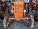 a large orange tractor parked in a large warehouse