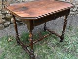 une petite table avec un plateau en bois posée dans l'herbe