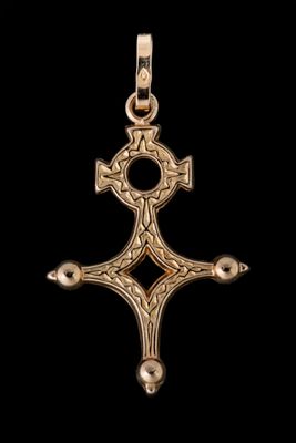 un pendentif en forme de croix en or, orné d'un motif celtique sur fond noir