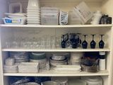 shelves filled with dishes and utensils in a kitchen