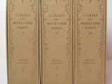 three books are lined up in a row on a white surface