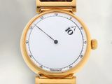 une image d'un gros plan d'une montre-bracelet sur une surface blanche