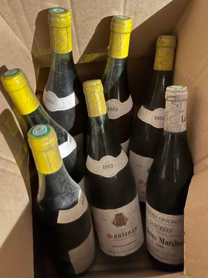 six bottles of wine in a cardboard box on a table