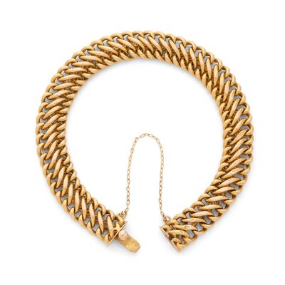 un bracelet en chaîne dorée muni d'un fermoir, sur fond blanc
