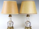 une paire de lampes anciennes avec des abat-jours dorés et un vase bleu et blanc