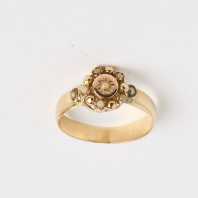 une image d'une bague en or avec une pierre rose au centre