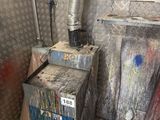 a dirty room with a dirty furnace and a trash can