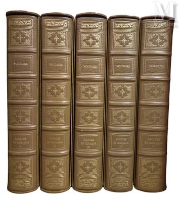 six livres anciens sont alignés sur une surface blanche