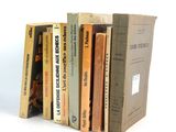 several books are stacked on top of each other on a white surface