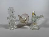 three glass figurines sitting on a white surface